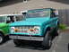 1973 Ford Bronco - A turquoise 1973 Ford Bronco is parked next to a green Bronco at a car meet.