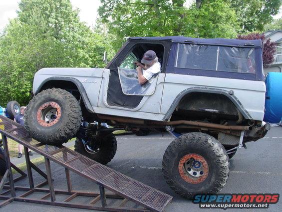 1973 Ford Bronco with large off-road tires on a ramp