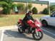 1988 Ford Bronco - A person in a suit rides a red sport motorcycle next to a white truck.