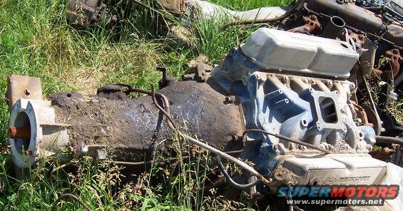 engine and transmission parts sitting in grass
