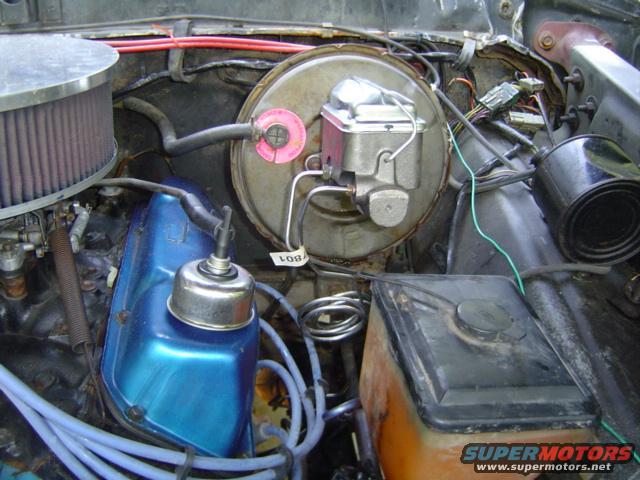 Engine bay with brake booster, master cylinder, air filter, and blue valve cover