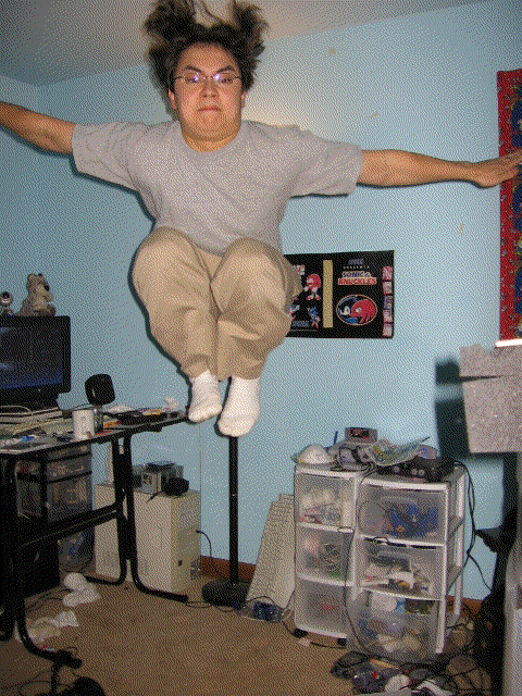 guy mid-air in a room with a computer desk and storage drawers