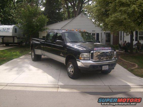 Black dually pickup truck with chrome grille and "BOOMER" decal on hood