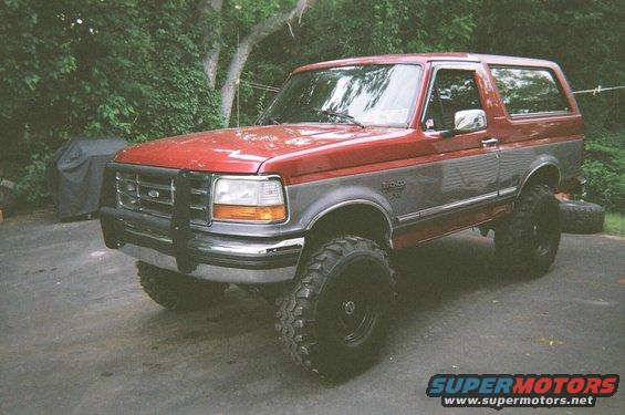 Red and gray 1994 Ford Bronco with large off-road tires