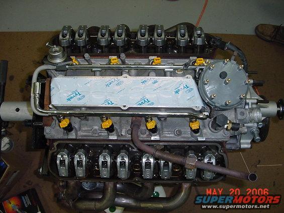 V8 engine with fuel injectors and valve covers visible. Tyvek material covers part of the intake manifold