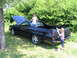 1973 Ford Ranchero - A black 1973 Ford Ranchero is parked on grass with its hood open, while two children interact with the vehicle.