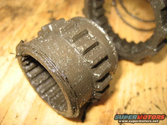 Greasy metal hub part with teeth, on a wooden surface