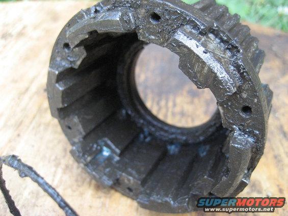 Close-up of a worn, greasy metal gear housing with visible teeth
