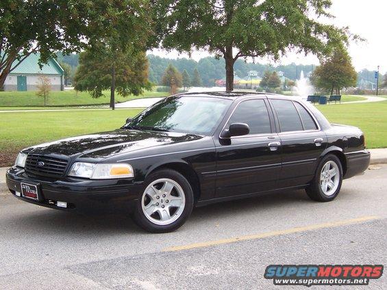 Black 2001 Ford Crown Victoria sedan parked on a road, front quarter view. Chrome trim and alloy wheels are visible