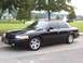 2001 Ford Crown Victoria - A black 2001 Ford Crown Victoria sedan is shown from the front quarter angle in a park setting.