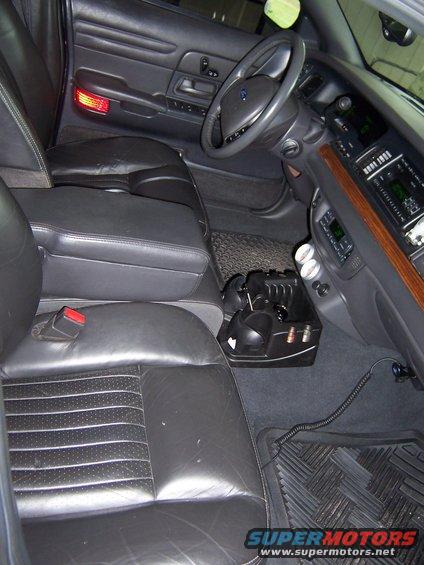 Front seats and dashboard of a 2001 Ford Crown Victoria. Black leather seats and black dashboard with wood trim
