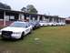 2003 Ford Crown Victoria - A line of sheriff's department Ford Crown Victoria police cars are parked on the grass in front of a building.