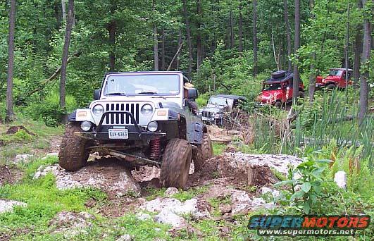 2003 Jeep Wrangler navigating rocky terrain with other Jeeps behind