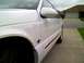 1995 Ford Thunderbird - A white 1995 Ford Thunderbird coupe is parked on a driveway, with a garage in the background.