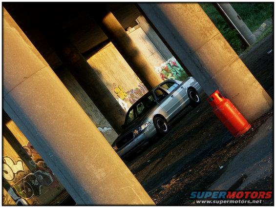 Silver 1998 Ford Crown Victoria 3q-front view under bridge