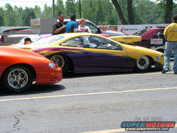 Yellow and purple drag car with racing decals, side view
