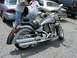 2006 Victory Kingpin - A silver motorcycle is parked in a lot, with two people standing nearby and other vehicles in the background.
