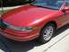 1996 Lincoln Mark VIII - A red 1996 Lincoln Mark VIII convertible is shown from the front quarter angle, highlighting its distinctive grille and headlights.