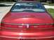 1996 Lincoln Mark VIII - The rear of a red 1996 Lincoln Mark VIII is shown, a full-width taillight bar and the Lincoln emblem.