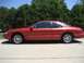 1996 Lincoln Mark VIII - Side view of a red coupe with a distinctive body style, possibly from the early to mid-1990s.