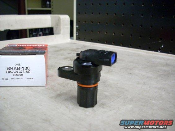Black automotive sensor with orange ring and blue connector, next to a Motorcraft box labeled BRAB-130