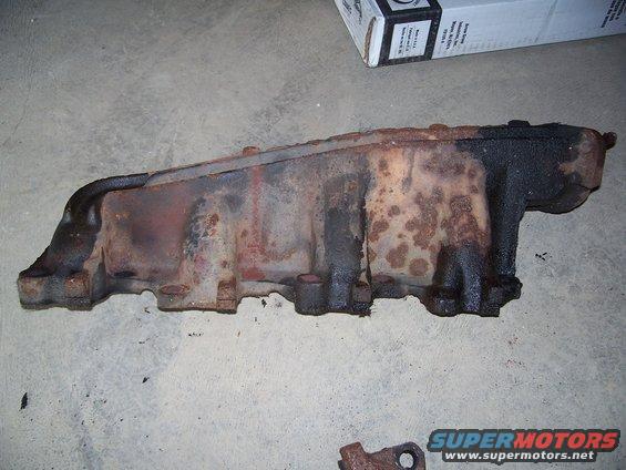 rusted exhaust manifold on concrete floor
