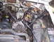 1971 Porsche 914 - The engine bay of a vehicle shows various components including the carburetor and alternator, with signs of wear and rust.