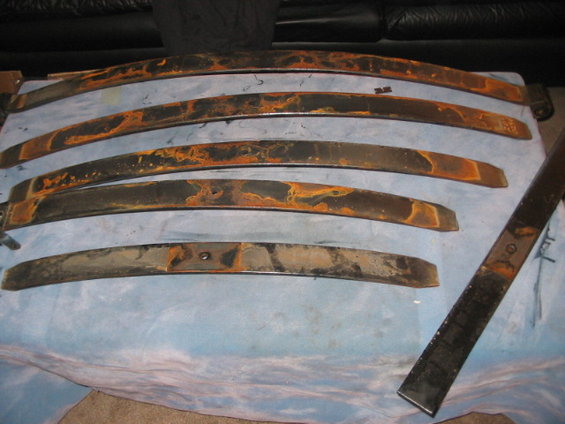 Several rusty leaf springs laid out on a blue cloth