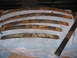 1991 Ford Bronco - Multiple leaf springs, showing significant rust and wear, are arranged on a surface.