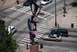 1996 Ford Bronco - An abstract sculpture stands prominently at a city intersection, with several vehicles navigating the street and crosswalks.