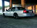 1998 Ford Crown Victoria - This 1998 Ford Crown Victoria is shown from the rear quarter angle, black wheels and an American flag decal on the fender.
