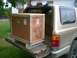 1995 Ford Probe - A large wooden crate is loaded into the back of a gold SUV.