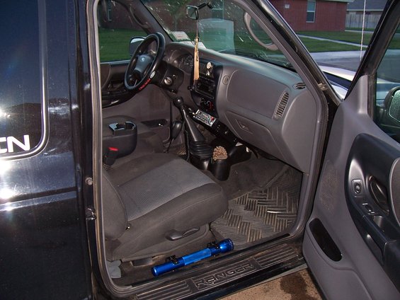 Interior of a black 2003 Ford Ranger showing dashboard, seats, and door panel