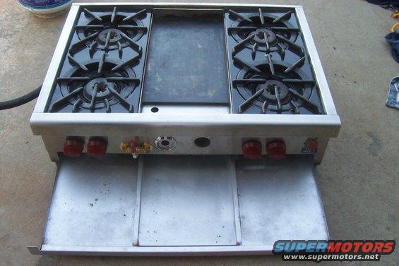 Commercial gas range with four burners and a griddle top, stainless steel body