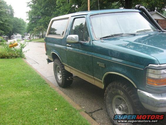 Teal 1996 Ford Bronco with tan trim and snorkel, parked on a residential street