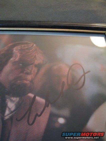 Autographed photo of a man with a beard and signature