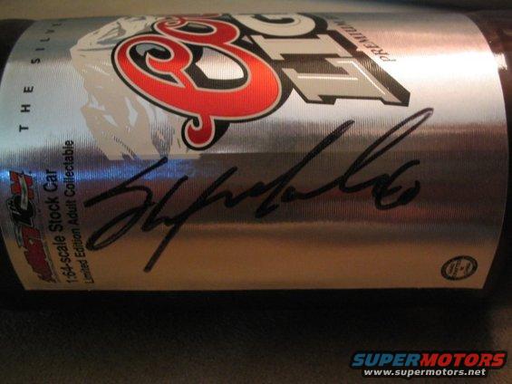 Silver collectible stock car with red and black logo and black signature