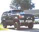 1989 Ford Bronco - This 1989 Ford Bronco is parked in front of a building with another car behind it.