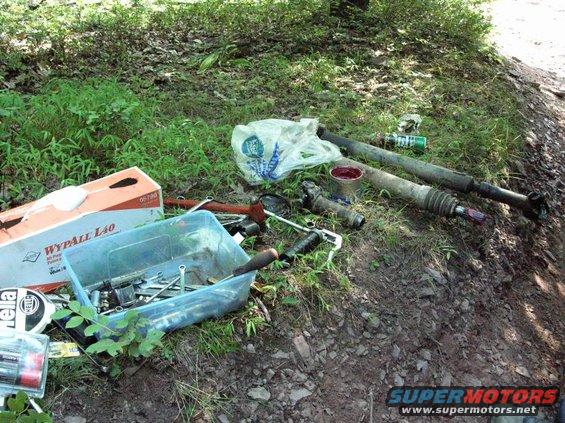 Driveshafts and tools scattered on the ground next to a box of WypAll L40