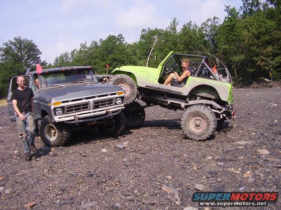 Gray Ford truck and green Jeep on rocky terrain