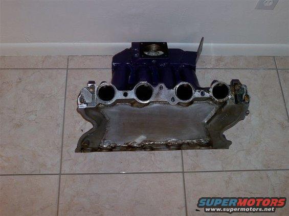 Purple intake manifold with four ports, on a tiled floor