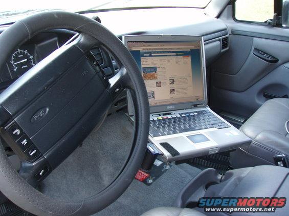 Steering wheel and dashboard of a 1990s Ford truck with a Dell laptop mounted