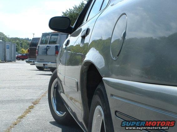 Side view of a car parked next to vans and portable toilets