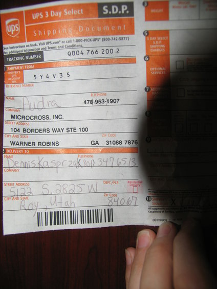 UPS shipping label with sender and receiver info, tracking number Q004 766 200 2