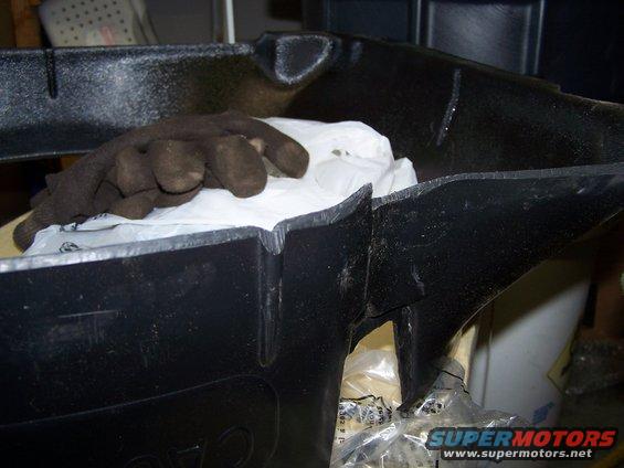 Black plastic part with a work glove and white plastic bag inside