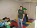 1988 Ford Bronco - A man stands in a room with a children's play structure and a table of items.