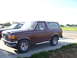 1990 Ford Bronco - Brown 1990 Ford Bronco parked on a paved surface with another vehicle beside it.
