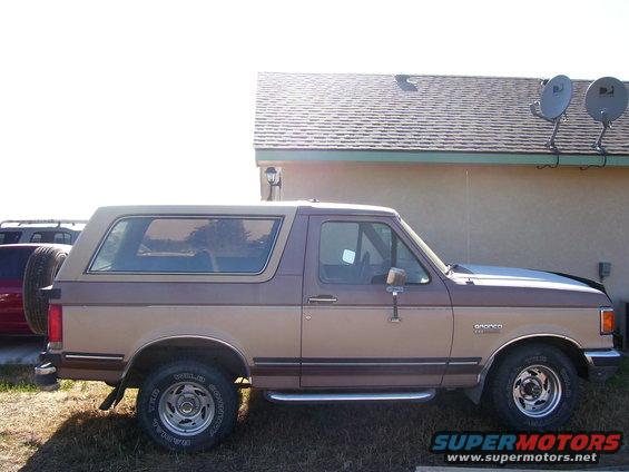 Two-tone brown Ford Bronco side view, showing spare tire on rear door