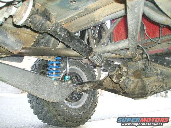 Undercarriage of a modified off-road vehicle showing suspension, driveshaft, and differential