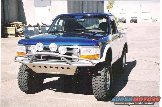 Blue and white Ford F-150 prerunner truck with off-road lights and bumper
